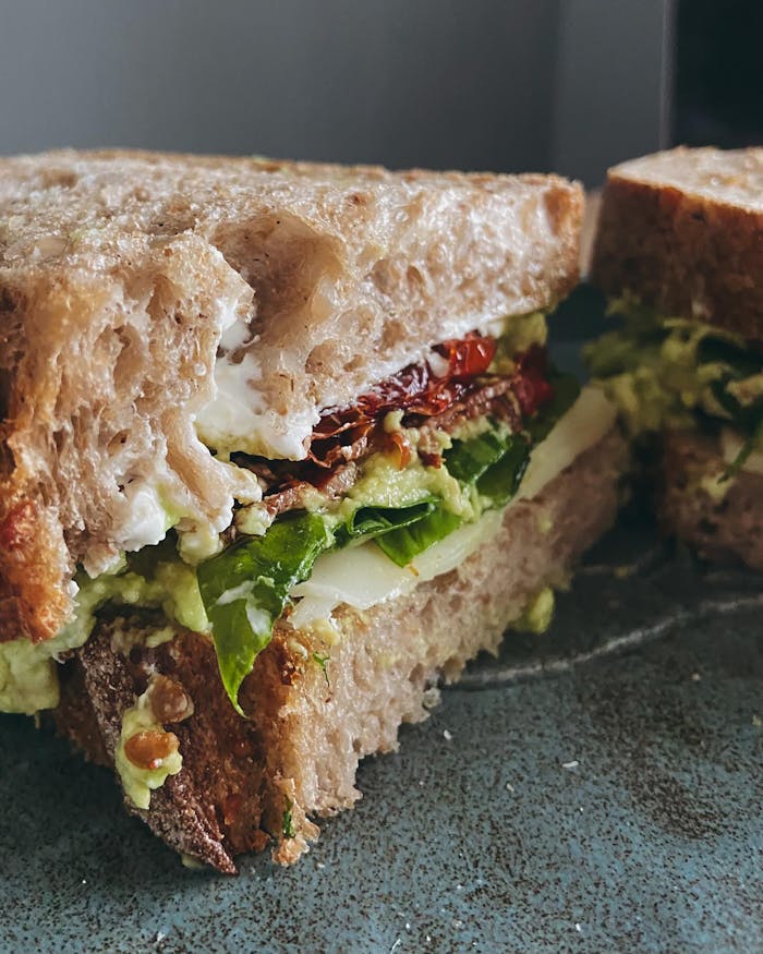 A sandwich with avocado, lettuce and tomato